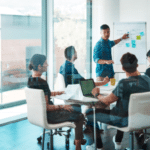 A group of professionals collaborating at a table in an office, discussing custom IT strategies and solutions.