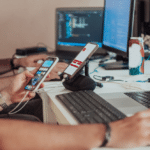 Two men focused on their laptops and phones at a desk, demonstrating effective mobile integration in a collaborative workspace.