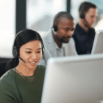 A woman in an office wearing a headset, engaged in proactive IT management tasks.