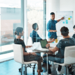 A group of professionals collaborating at a table in an office, discussing custom IT strategies and solutions.